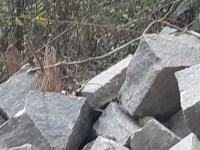 Gromadzenie materiałów na budowę. Kamień ciosany do budowy fundamentów.